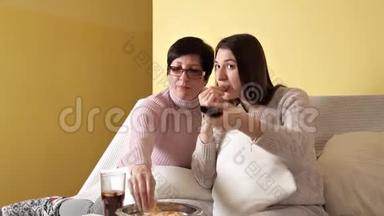 妈妈和女儿一边吃薯片，一边<strong>喝</strong>电视，一边<strong>喝可乐</strong>.. 家里的舒适气氛